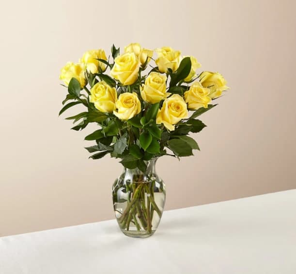 Ray of Sunshine Yellow Rose Bouquet - Brighten up someone's day with roses. Picked fresh from the farm, this arrangement is composed of a cheerful selection of a dozen yellow roses in a clear glass vase.  Yellow roses are about 17"H by 14"W.