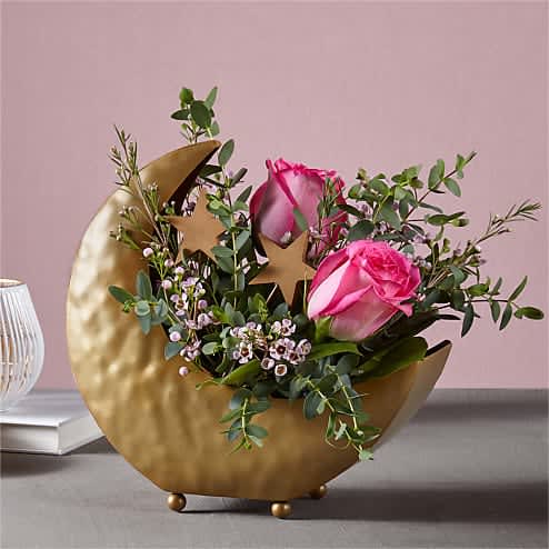 Over the Moon Bouquet - Express the extent of your adoration with the Over the Moon Bouquet. A pop of pink shines through the roses, all nestled in a bed of waxflower and eucalyptus. Wake up from your daydream to enjoy this cosmic bouquet delicately designed in a metal moon vase and scattered with stars.