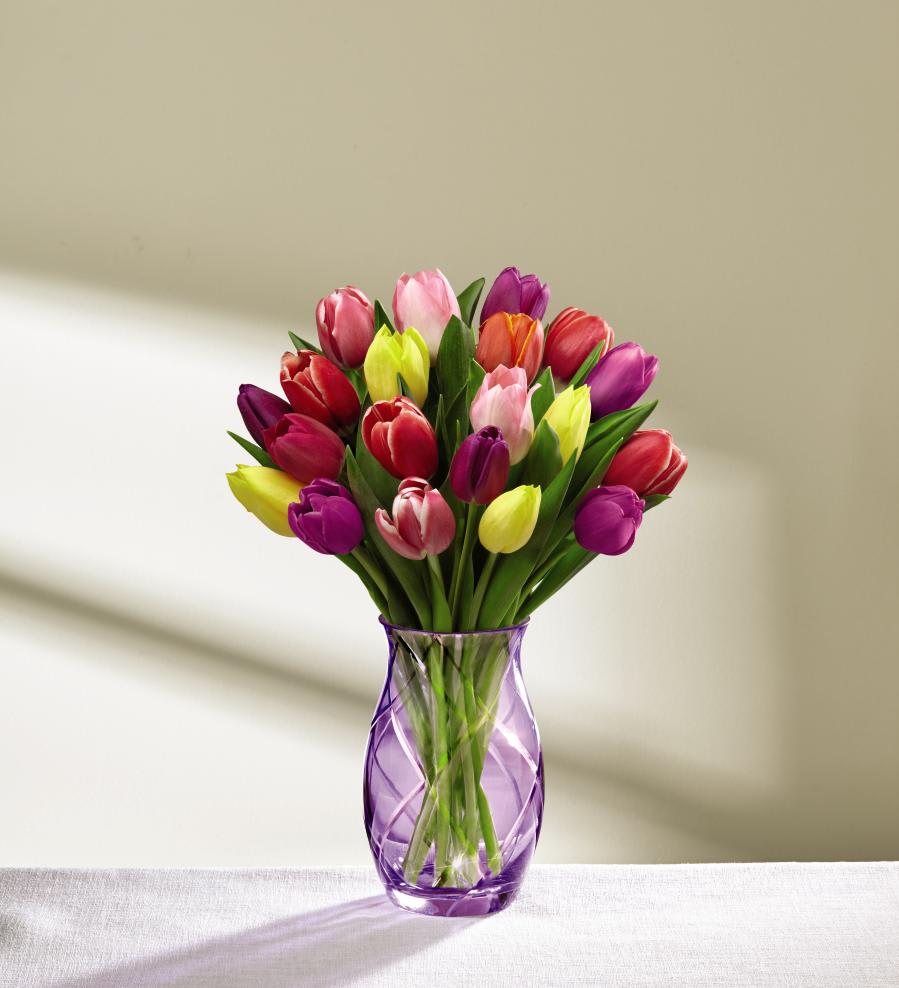 The FTD Spring Tulip Bouquet by Better Homes and Gardens - Deluxe - FTDÂ¨ proudly presents the Better Homes and GardensÂ¨ Spring Tulip Bouquet. Nothing says spring to our hearts and our eyes more than the beauty of fresh and colorful tulips! Looking as if it was pulled right out of the pages of Better Homes and GardensÂ¨ magazine this gorgeous bouquet brings together a collection of tulips in every shade, including yellow, red, purple, pink, and orange to create a simply dazzling gift. Presented in a keepsake purple glass vase, this spring flower arrangement is an excellent way to celebrate the season with those near and dear to your heart. GOOD bouquet includes 15 stems. Approx. 14"H x 9"W. BETTER bouquet includes 20 stems. Approx. 15"H x 10"W. BEST bouquet includes 25 stems. Approx. 15"H x 11"W. EXQUISITE bouquet includes 30 stems. Approx. 16"H x 11"W.