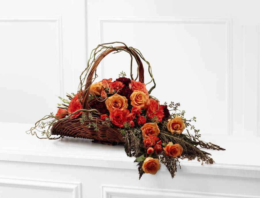 FTD Fare Thee Well Arrangement - The FTD Fare Thee Well Arrangement is a rich display of   sun-kissed elegance that symbolizes the dawn of their eternal light.   Orange roses, bi-colored orange roses, burgundy carnations, orange spray   roses, and a variety of lush greens accented with curly willow branches   are artfully arranged in a natural willow fireside handled basket to   create a wondrous presentation of gorgeous grace to honor the life of   the deceased.    17h x 43w