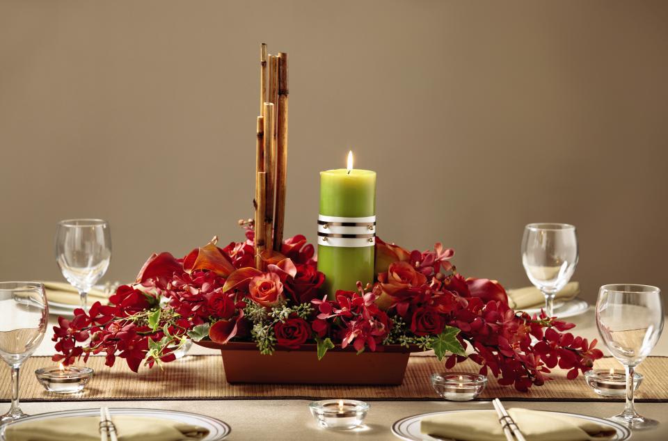 FTD Dramatic Garden Centerpiece - The FTD Dramatic Garden Centerpiece has an alluring elegance that will   make your wedding celebration stand out from the rest. Red mokara   orchids, mango mini calla lilies, red roses, Leonidas Roses, variegated   ivy, seeded eucalyptus and curly willow tips are brought together to   form an exquisite arrangement offset by a green pillar candle and river   cane stems for a display of dramatic sophistication. Approx. 18H x   30W.   