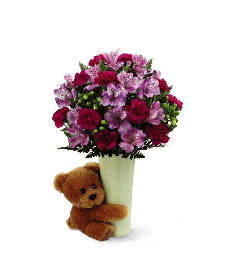 The FTD Big Hug Bouquet - The FTD Big Hug Bouquet is the perfect way to give them a squeeze when they need it! Everybody needs a hug now and then and this bouquet,   featuring a 6-inch bear hugging a simple, pale green ceramic vase, is   the perfect way to indulge your special someone. Lavender Peruvian   lilies, magenta mini carnations and lush greens create the perfect   expression of love, gratitude and cheer making this a gift they won't   soon forget. GOOD bouquet includes 7 stems. Approximately 14H x 9W.   BETTER bouquet includes 11 stems. Approximately 15H x 11W. BEST   bouquet includes 13 stems. Approximately 16H x 12W.   
