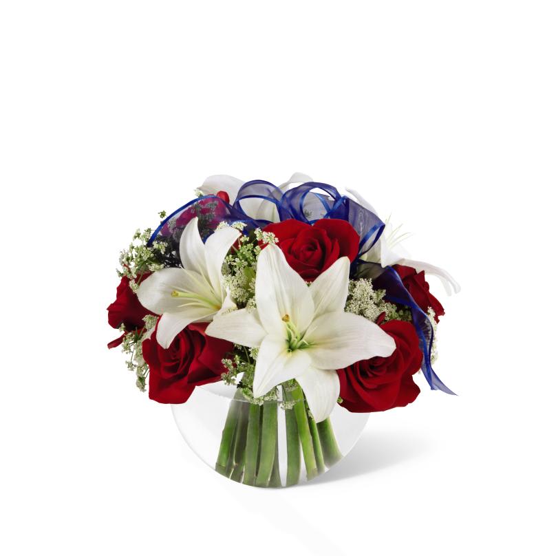 FTD Independence Bouquet - The FTD Independence Bouquet will dazzle your recipient this Summer   just in time for the exciting celebration that the Fourth of July   brings. Brilliant red roses and white Asiatic lilies are subtly accented  with Queen Anne's Lace and a sheer blue ribbon all perfectly presented   in a clear glass bubble bowl creating a gorgeous gift that will make   their holiday complete. 9h x 8w  