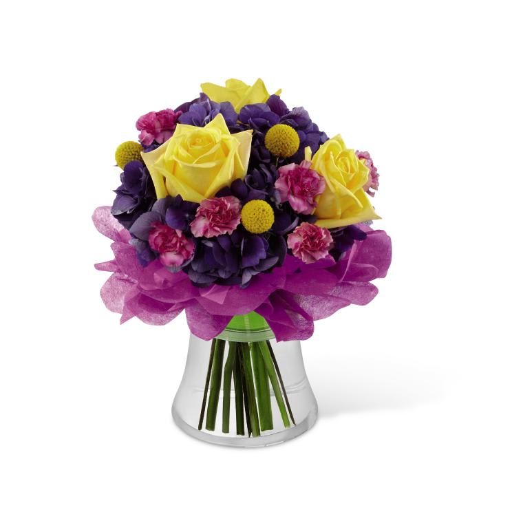 FTD Colors Abound Bouquet - The FTD Colors Abound Bouquet uses roses and hydrangea to send a   flower arrangement blooming in eye-catching color! Bright yellow roses,   fuchsia mini carnations, purple hydrangea, and yellow craspedia create   an incredible bouquet accented at the base with hot pink and yellow wrap   sheets. Presented in a clear glass vase tied with a green wired ribbon,   this arrangement is set to celebrate their birthday, extend your   congratulations or to just brighten their day. GOOD bouquet includes 9   stems. Approx. 11H x 10W. BETTER bouquet includes 12 stems. Approx.   11H x 10W. BEST bouquet includes 16 stems. Approx. 12H x 11W. 