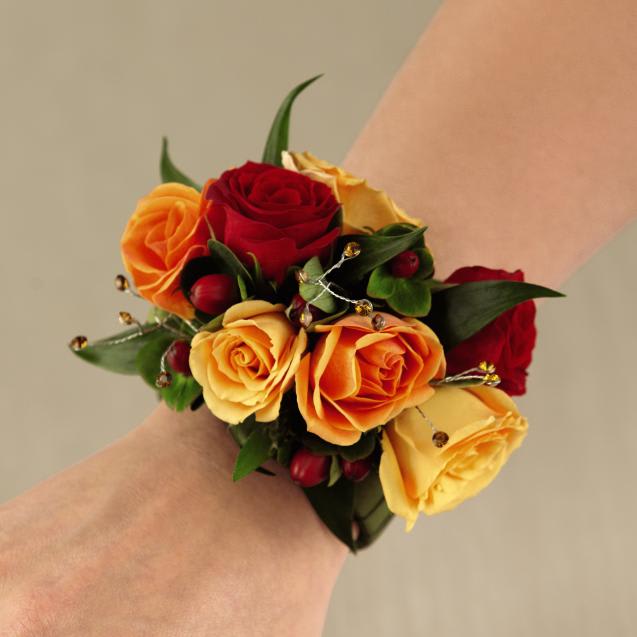 FTD Sweet Sunshine Wristlet - The FTDÂ® Sweet Sunshineâ¢ Wristlet is a ray of warm sunshine to honor any   of the special women in your life on your wedding day. Red, orange, and   yellow spray roses are accented with red hypericum berries, lush   greens, and topaz rhinestone pics and perfectly arranged on a wristlet   covered with a sage grosgrain ribbon for an incredible look. Approx. 5âH   x 3âW.   