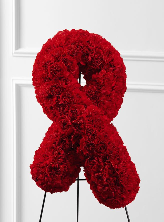 FTD Heartfelt Ribbon Easel - The FTD Heartfelt Ribbon Easel is a beautiful, vibrant symbol of   the ongoing fight against heart disease to be displayed at their final   farewell service. Red carnations are elegantly shaped into the shape of a   ribbon to create a presentation of hope during this time of grief and   loss. Displayed on a wire easel.    24""h x 15""w