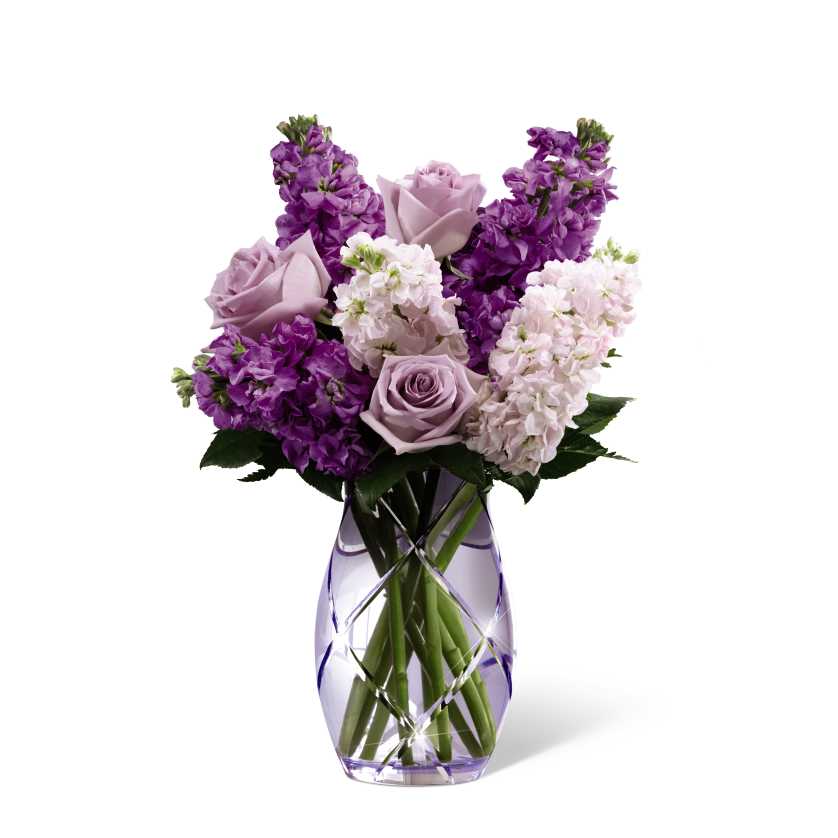 Purple and lavender flowers arranged in a clear vase