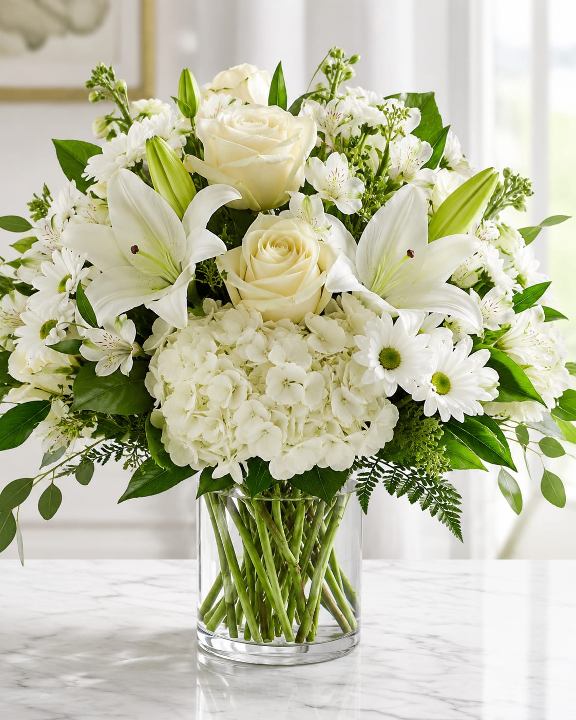 Petal Perfection's Serene Peace  - A serene cluster of pure white roses, lilies, hydrangeas, alstroemeria and daisy-like blooms makes a calming statement for sympathy, a wedding, or any occasion that calls for quiet elegance. This sympathy arrangement in a clear glass vase presents a formal, rounded silhouette so the person you're thinking of will feel comforted and seen by its tranquil, refined presence.  The bouquet is densely layered: creamy white roses and full hydrangea heads anchor the design while fragrant lilies and delicate alstroemeria add texture and movement; small daisy-like flowers and fresh green foliage weave through the composition, with unopened lily buds adding hopeful, upward lines. The arrangement sits in a simple clear glass vase that highlights the clean palette of white and green and suits both home and ceremonial settings.  Perfect for offering condolences, honoring a life, or dressing a wedding table, this piece communicates sympathy and elegance without fuss. Standard sizing offers a full, rounded presentation ideal for tabletops or entry consoles; like most mixed arrangements, keep water fresh and trim stems every few days to maintain its pristine look.