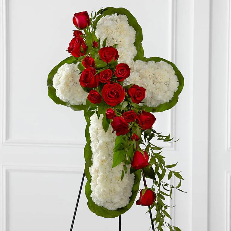 Cross-shaped floral tribute with red roses and white carnations