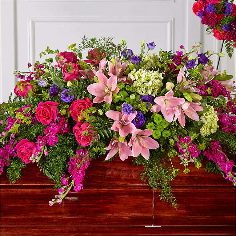 Large mixed floral arrangement with pink lilies, roses, and purple blooms