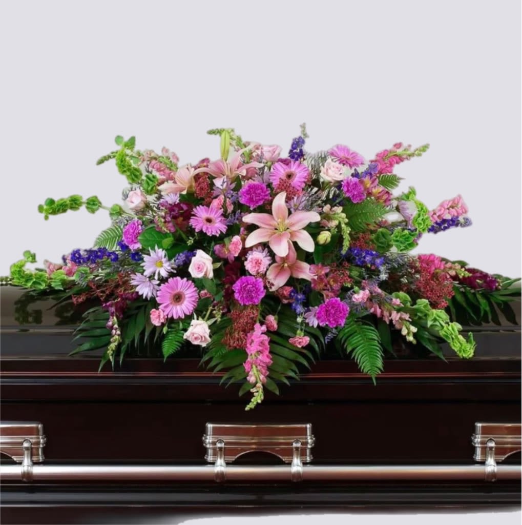 Large pink and purple floral spray on a dark casket
