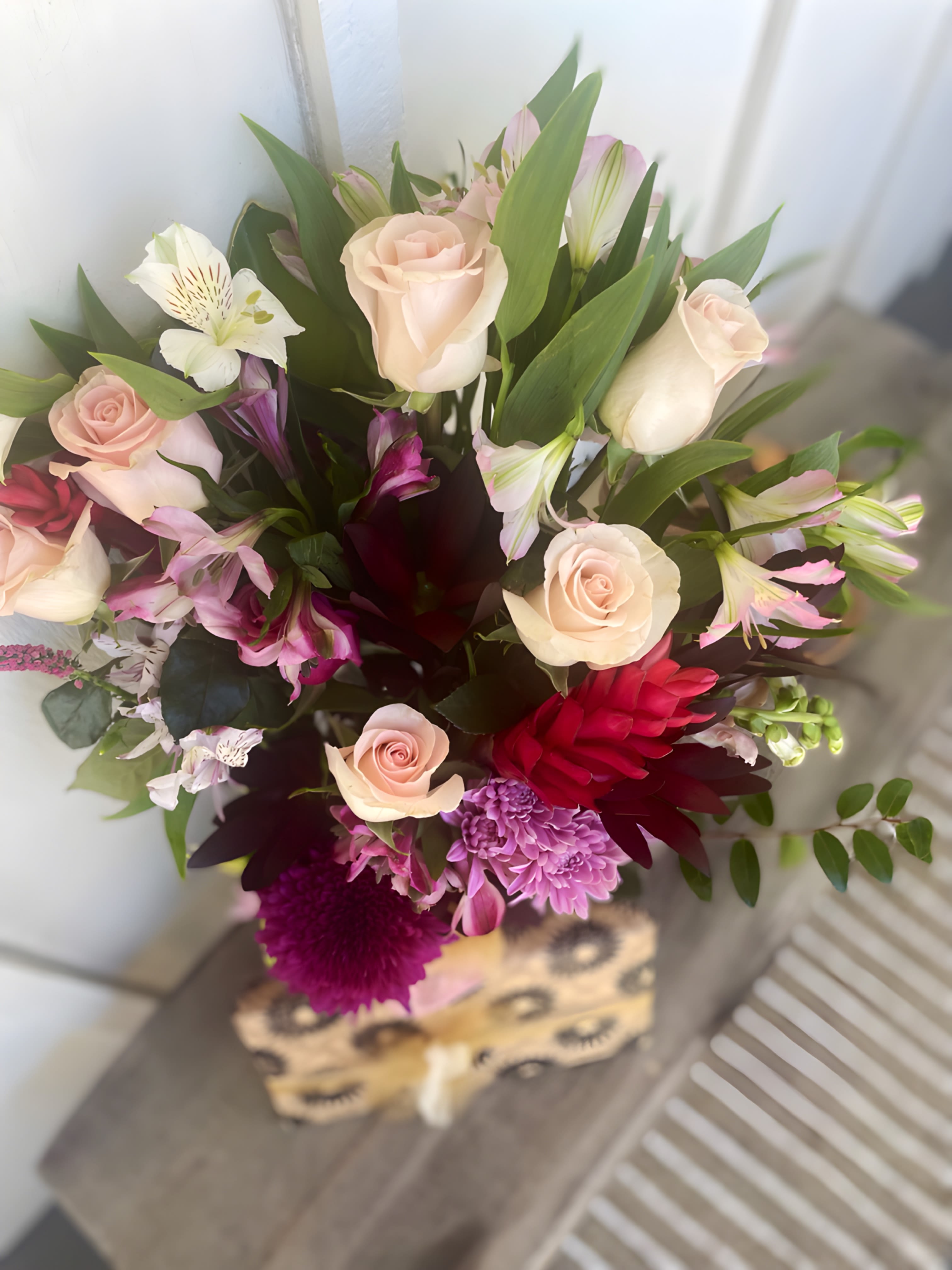 Mixed bouquet of pale roses, pink alstroemeria, and purple blooms
