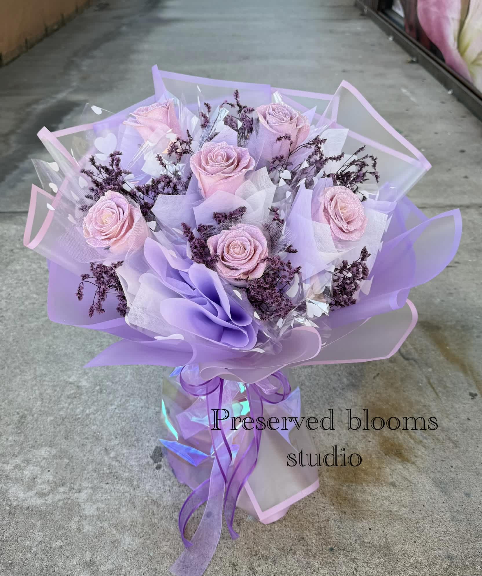 Bouquet of pale pink roses wrapped in lavender paper