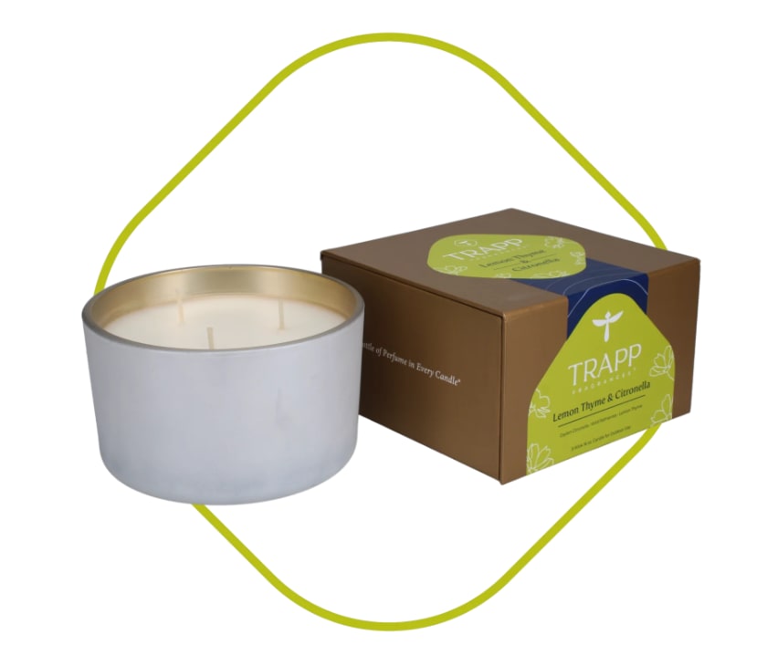 White candle in a metal tin beside a boxed candle set
