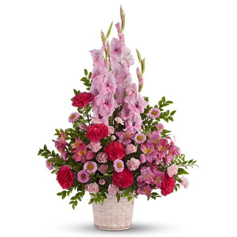 Pink and red floral arrangement in a woven basket