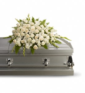 White floral spray on a gray casket