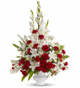 Tall red and white floral arrangement in a white urn