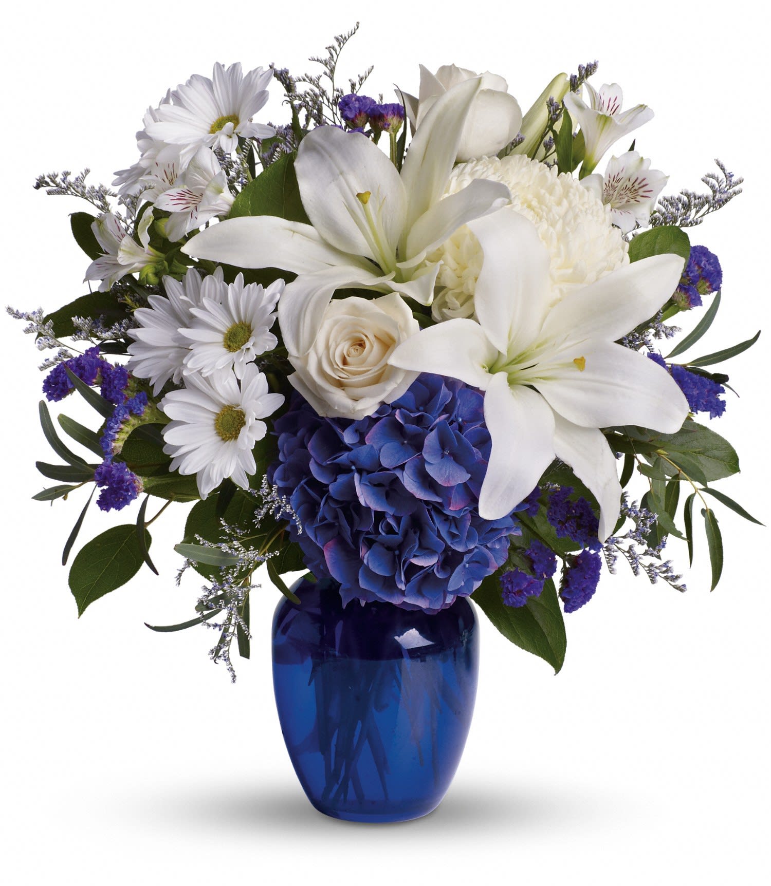 White lilies and daisies with blue hydrangea in a cobalt vase