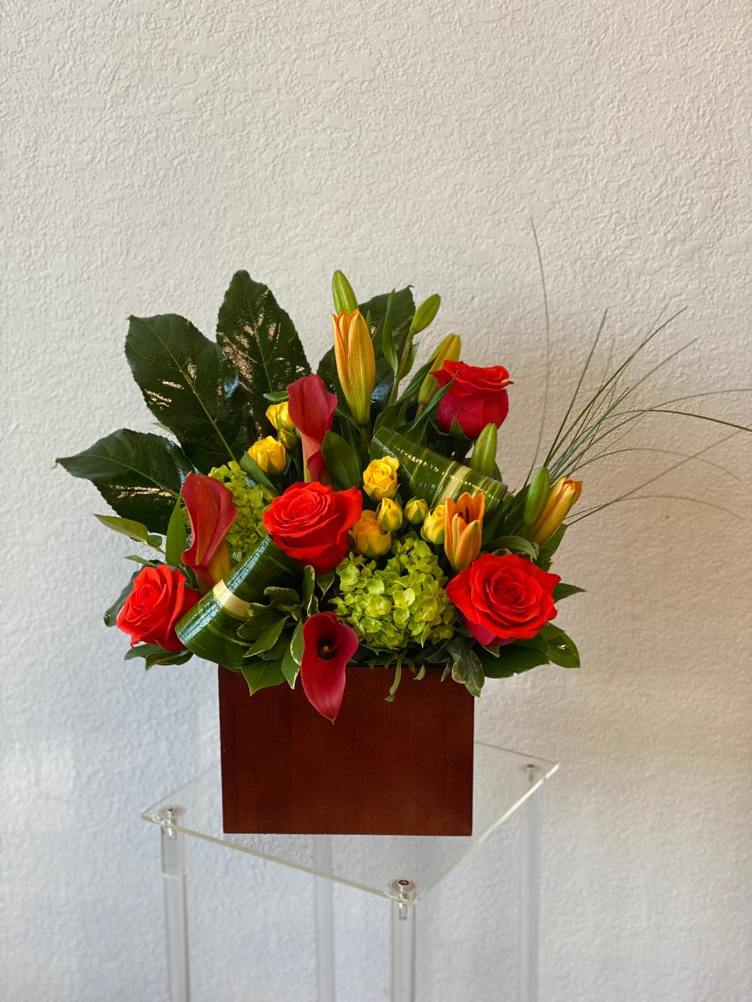 Red roses and calla lilies arranged in a wooden box