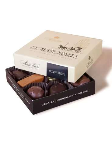 Open box of assorted chocolates with a lid on top