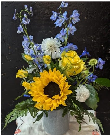 He Arrived - Ceramic vase with sunflower, roses, blue delphinium, white scabiosa and assorted greens