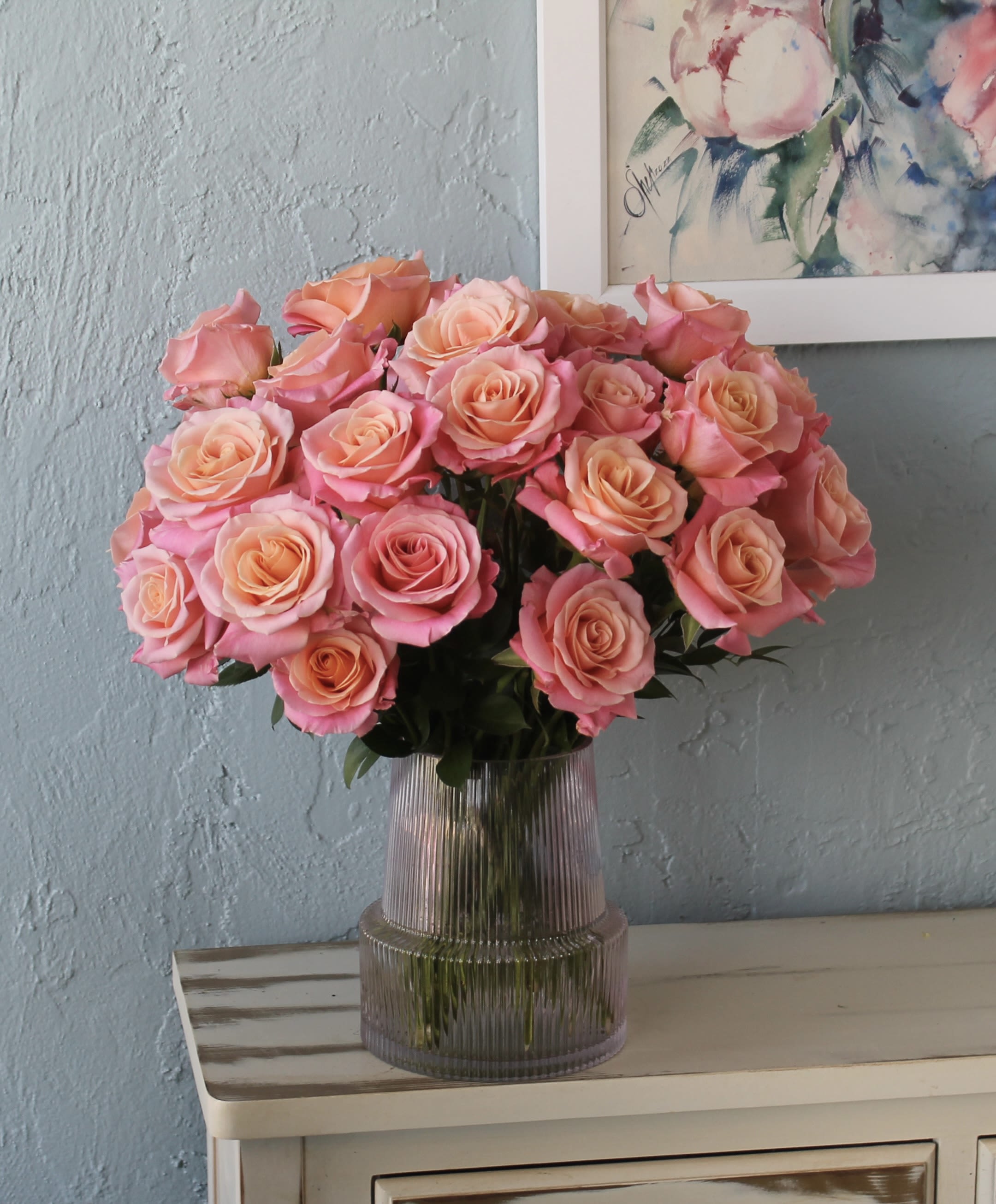 Pink and peach roses arranged in a ribbed glass vase