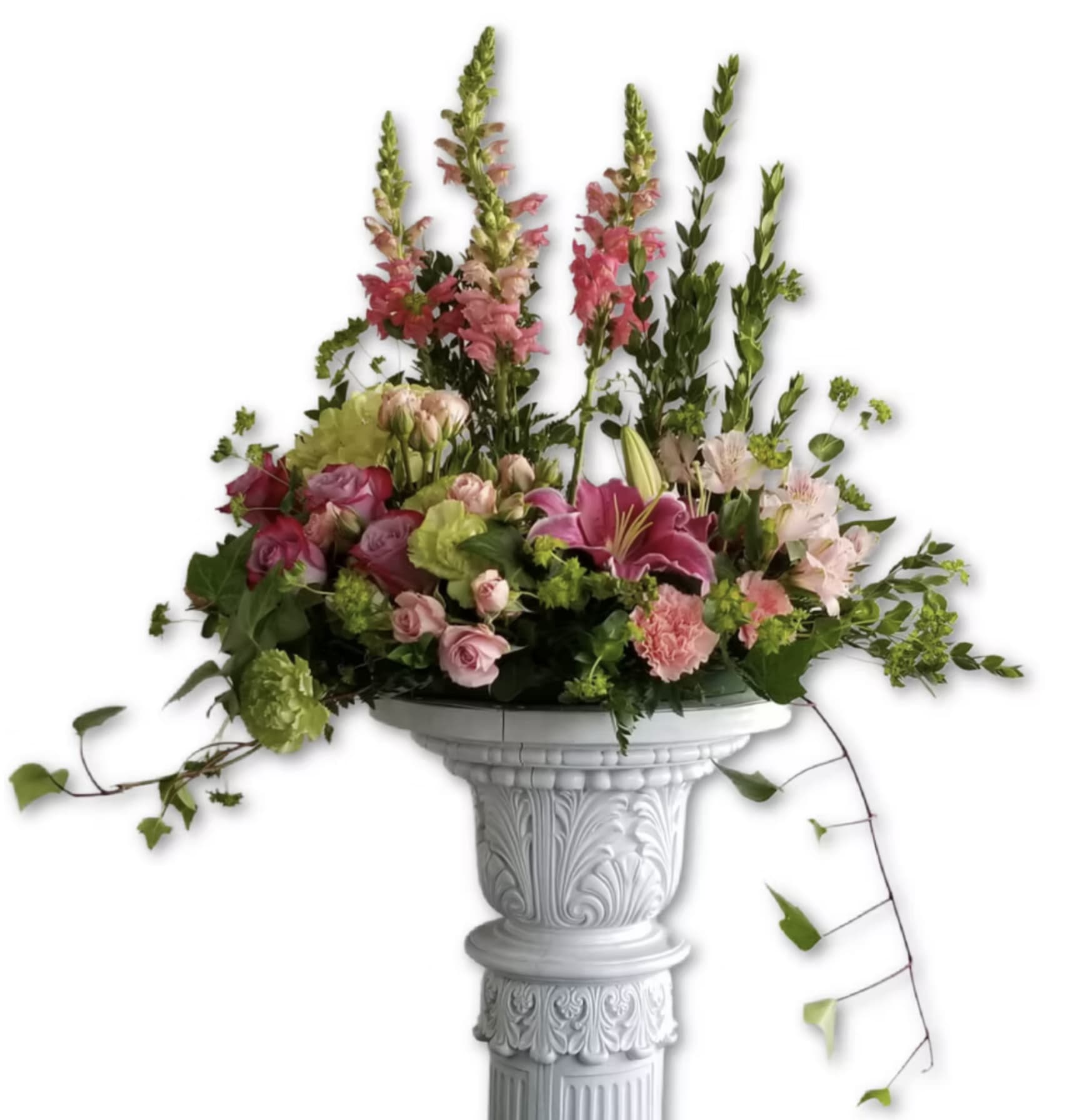Tall pink and green mixed flower arrangement on an ornate white pedestal column