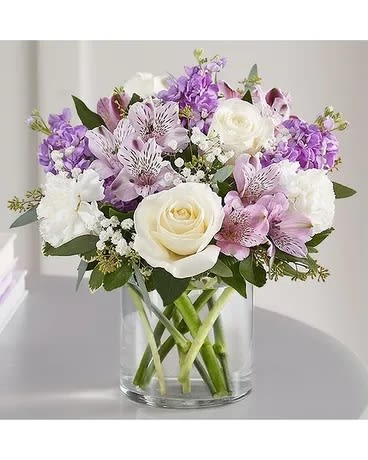 Bouquet of white and lavender flowers in a clear glass vase