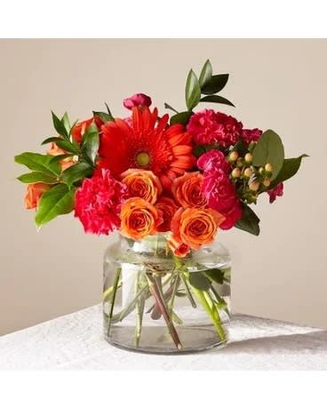 Bouquet of red and orange flowers in a clear glass vase