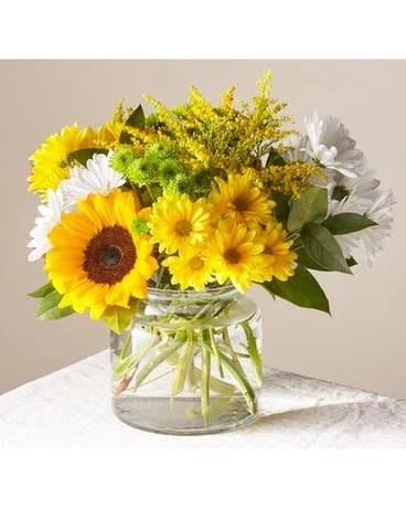 Sunflowers and white daisies in a clear glass vase