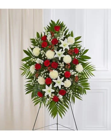 Standing floral spray with red and white flowers on a tripod easel