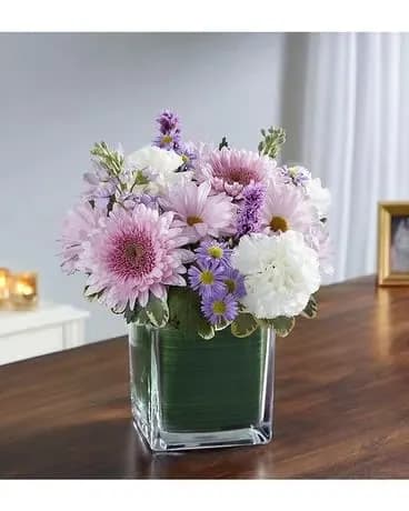 Pink and white daisy bouquet in a square glass vase
