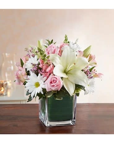Pink and white flower arrangement in a square glass vase