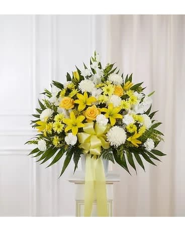 Yellow and white floral standing spray with a ribbon bow