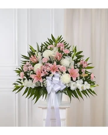 Standing floral spray with pink and white flowers and a white ribbon