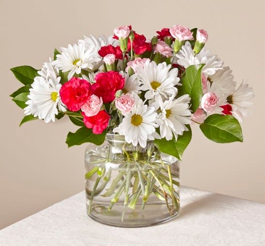 Bouquet of white daisies and pink carnations in a clear glass vase
