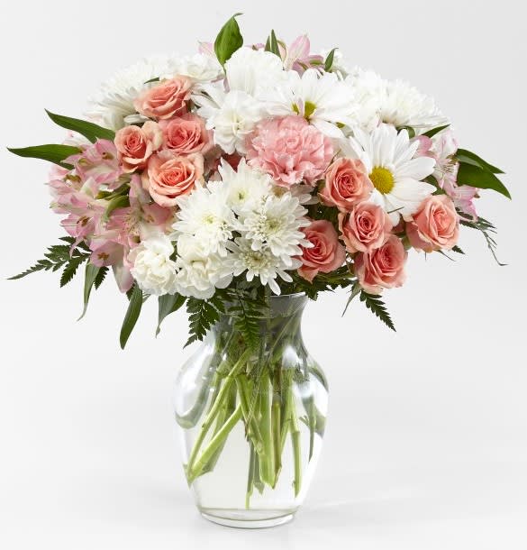 Pink roses and white daisies in a clear glass vase