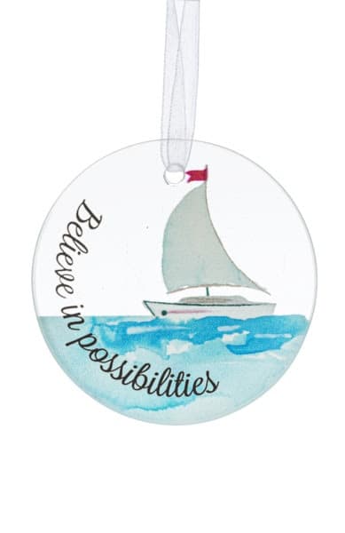 Round ornament with watercolor sailboat on blue water and the phrase 'Believe in possibilities'.