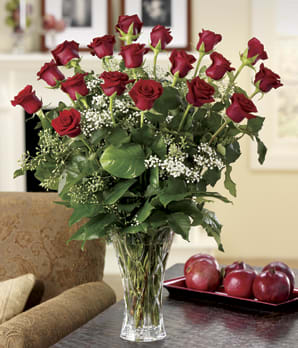 Red roses arranged in a clear glass vase