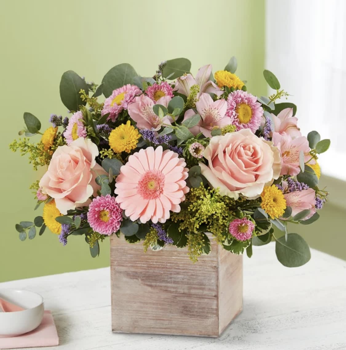 Pink roses and mixed daisies in a wooden box