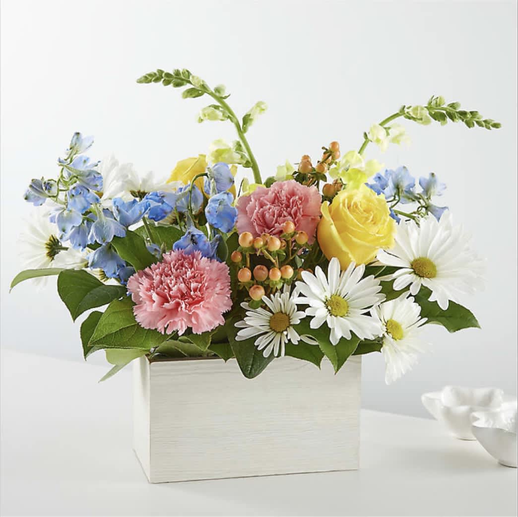 Mixed bouquet in a white box with yellow roses, pink carnations, and white daisies