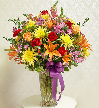 Beautiful  Bright Vase Arrangement - Product ID: 91391     Hand-designed arrangement of fresh red and peach roses, lilies, snapdragons, spider mums, alstroemeria, carnations and more Accented with salal, seeded eucalyptus, ruscus and more Presented in a footed clear glass vase; measures 11"H  ,  Our florists choose only the freshest flowers available, so colors and varieties may vary Arrangement measures approximately 34"H x 28"L