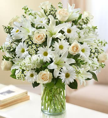 All White BOUQUET BY ENCINITASFLORIST - Product ID: 95380   Eall-white arrangement of roses, lilies, stock, daisy poms and monte casino. Bouquet of the freshest white roses, lilies, stock, daisy poms and monte casino, accented with variegated pittosporum, salal and myrtle Hand-designed by our expert florists in a classic glass cylinder vase; vase measures 8"H Can be sent to the home of friends, family members or business associates, or to the funeral service Large arrangement measures approximately 24"H x 22"L Medium arrangement measures approximately 22"H x 20"L Small arrangement measures approximately 20"H x 18"L Our florists hand-design each arrangement