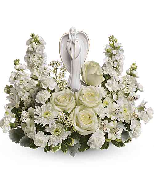 White floral arrangement with an angel figurine in the center