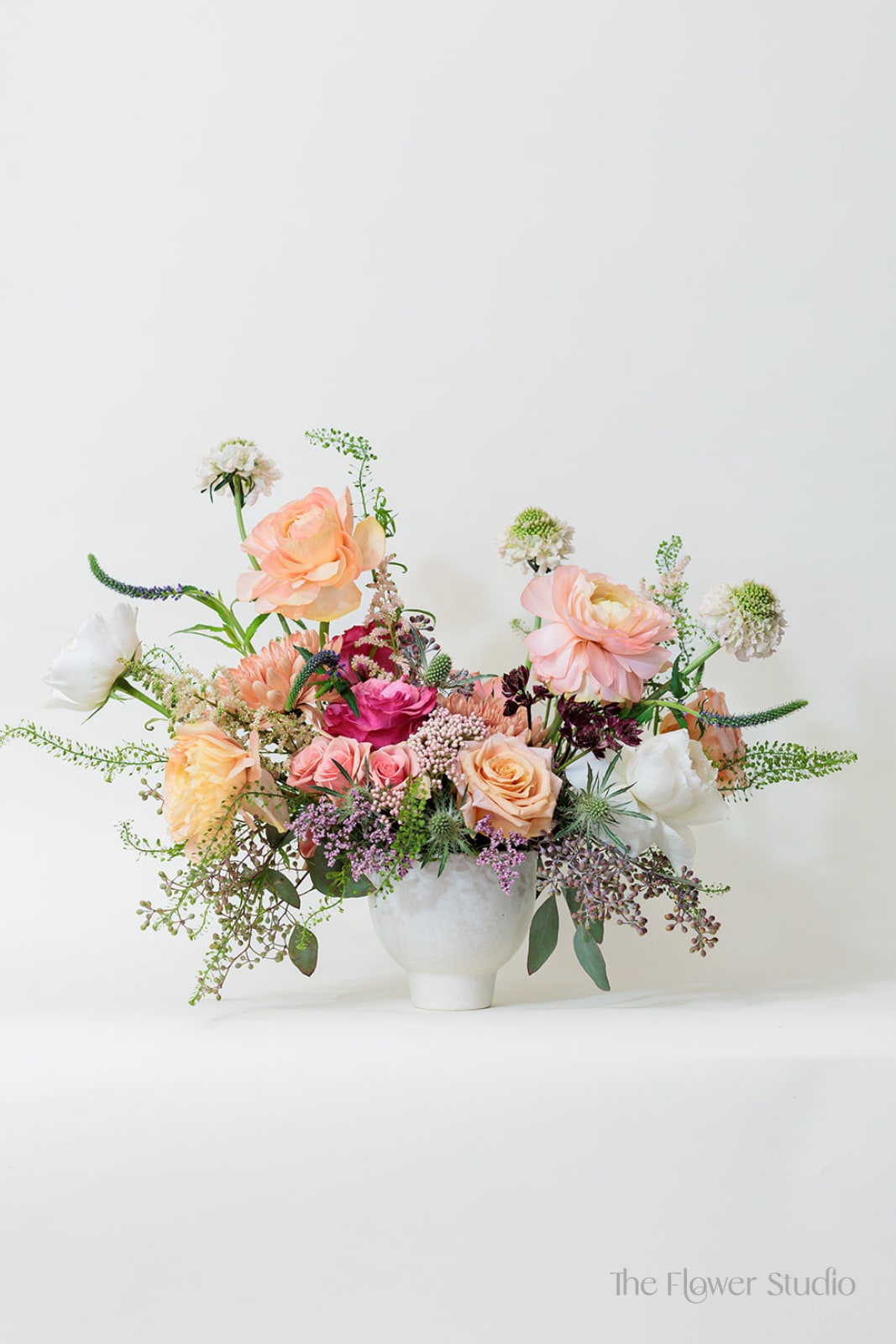 Mixed pastel flower arrangement in a white vase