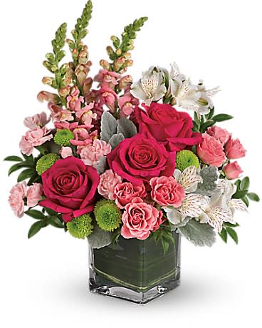 Pink and white floral arrangement in a square glass vase