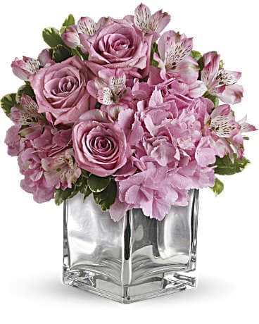 Pink roses and alstroemeria in a clear square vase