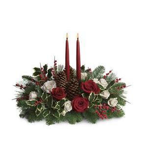 Holiday centerpiece with red candles, roses, and pinecones