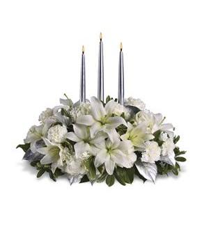 White floral centerpiece with three tall candles