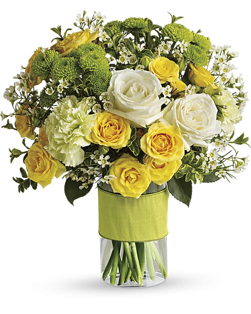 Yellow and white roses in a clear glass vase with green button mums